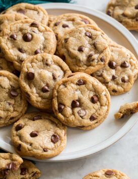 Plate full of browned butter chocolate chip cookies overlapping.