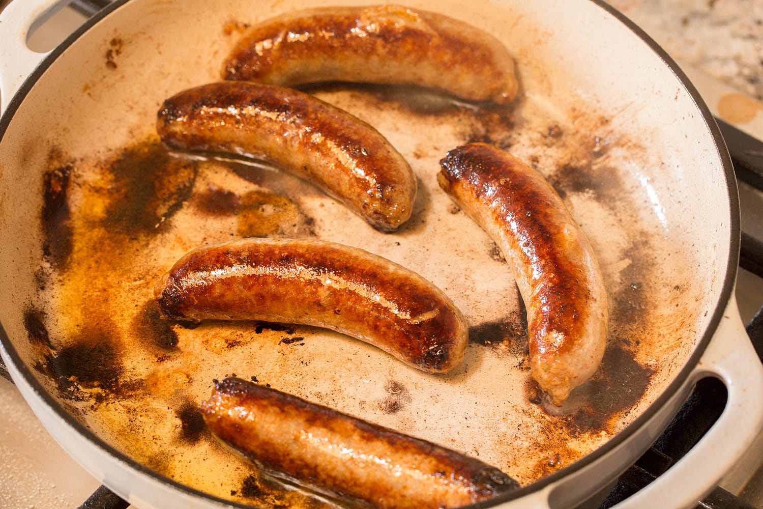 Italian sausage links shown in skillet after browning.